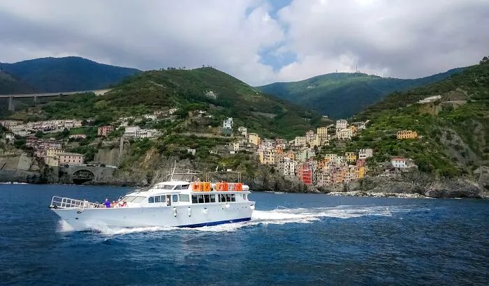 White boat cruising near colorful coastal town vacation destination