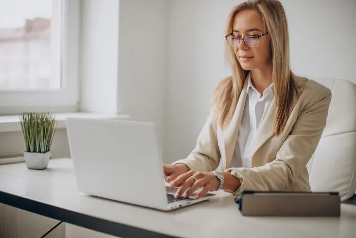 A young female professional working on her laptop, discussing subtle sexism experiences in office