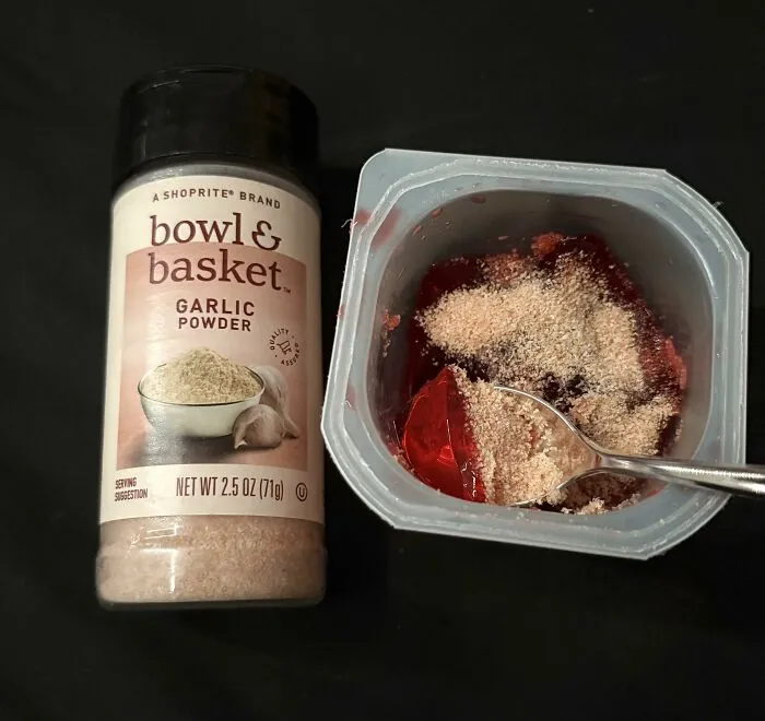 A container of red gelatin sprinkled with garlic powder, showing weird food combinations