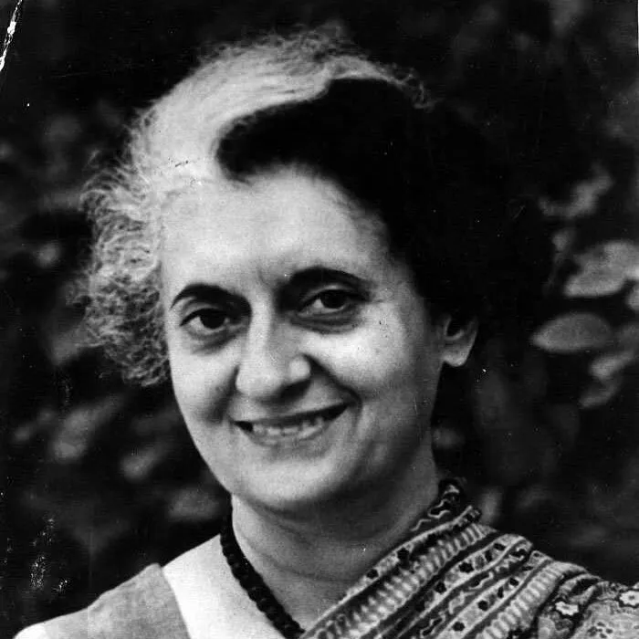 A black and white photo of Indira Gandhi, a significant woman in history, smiling.