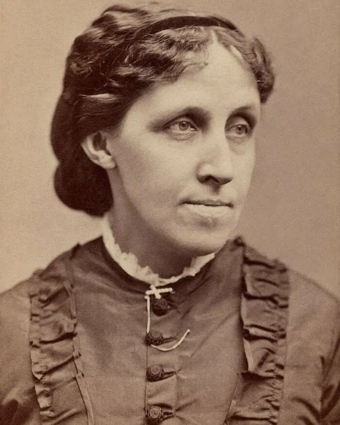 Sepia portrait of Louisa May Alcott, a famous woman in history, looking off to the side.