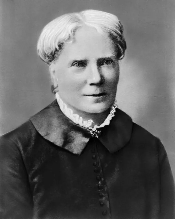 Black and white portrait of a woman with light hair and a ruffled collar, significant in women in history.