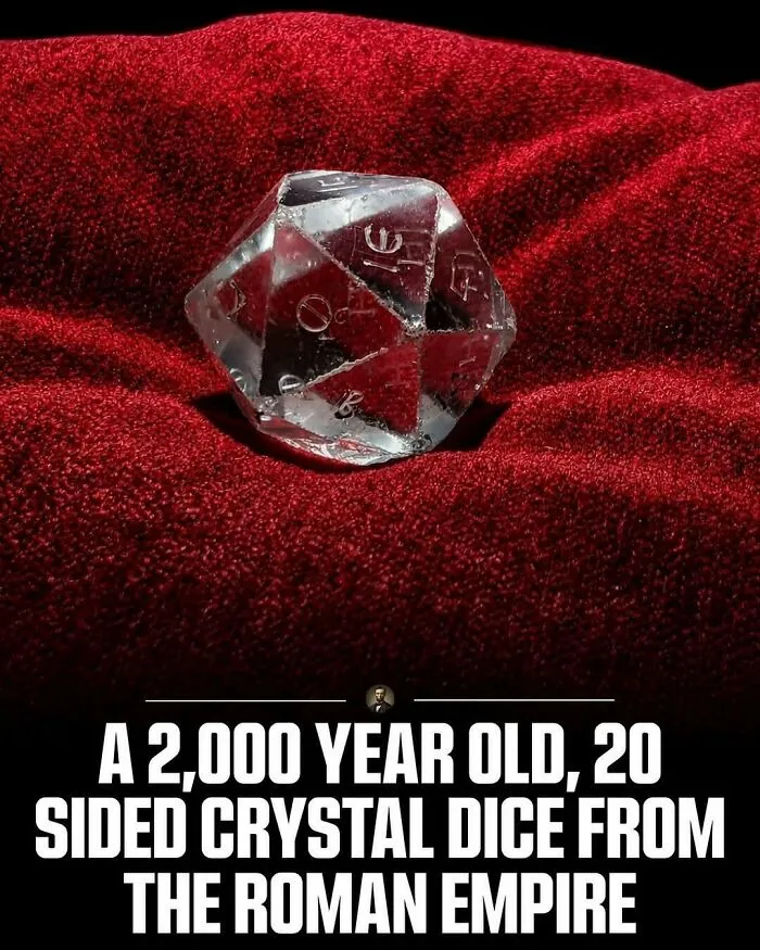A 20-sided crystal dice from the Roman Empire resting on red fabric, representing photos from history