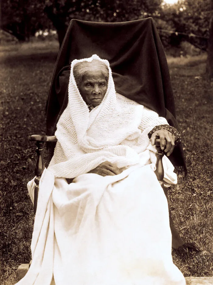 Harriet Tubman, a revered woman in history, seated in a chair, wrapped in a white shawl.