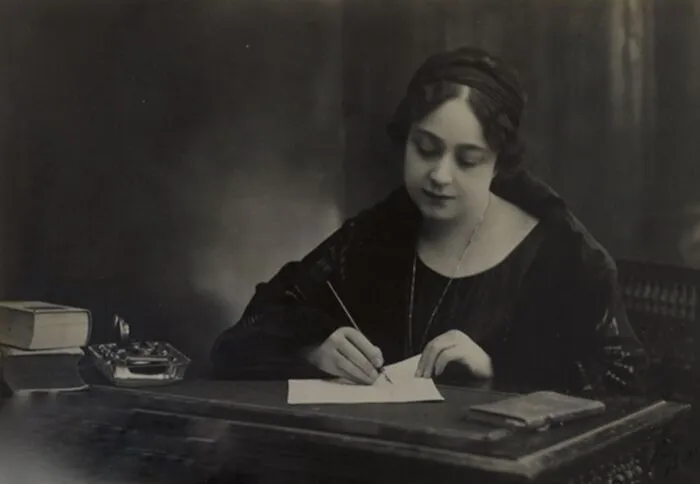 A woman in history writing at a desk, symbolizing the literary contributions of women in history.
