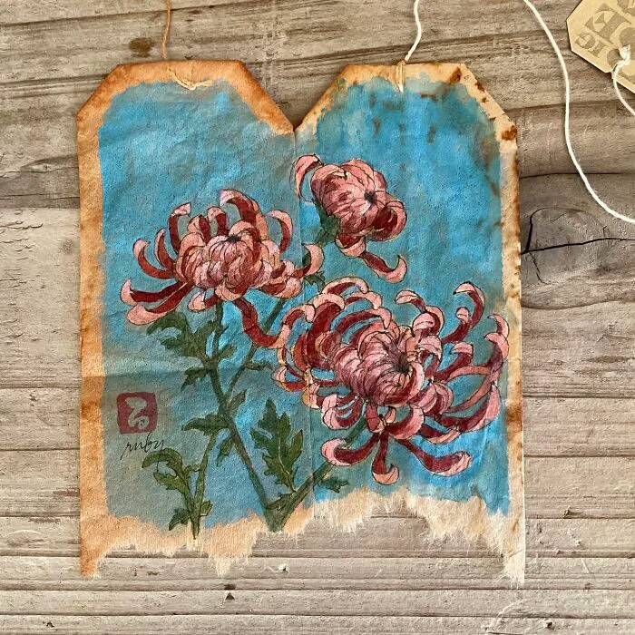 Pink chrysanthemum flowers painted on used tea bags as delicate miniature paintings