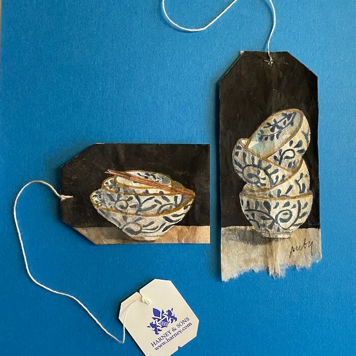 Blue and white ceramic bowls depicted in delicate miniature paintings on dark used tea bags