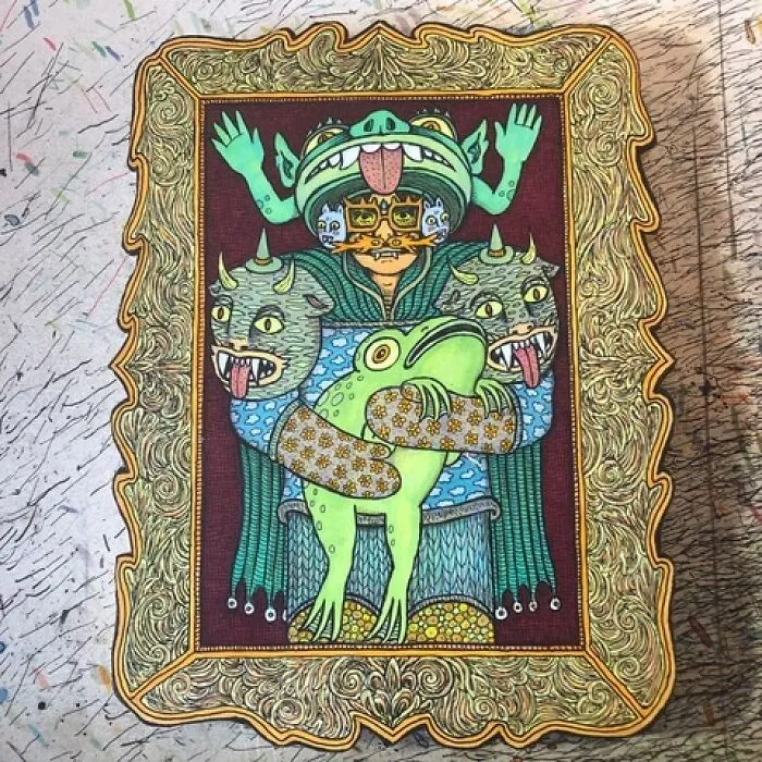 Theo Ellsworth artwork of a figure holding a large green frog with two-headed horned creatures in ornate frame