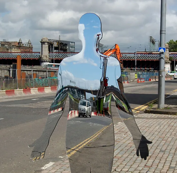 Reflective sculptures of human figures in urban construction area