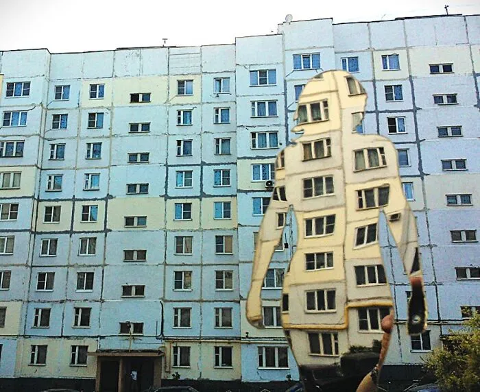 Reflective sculpture shaped like a person mirroring apartment building facade