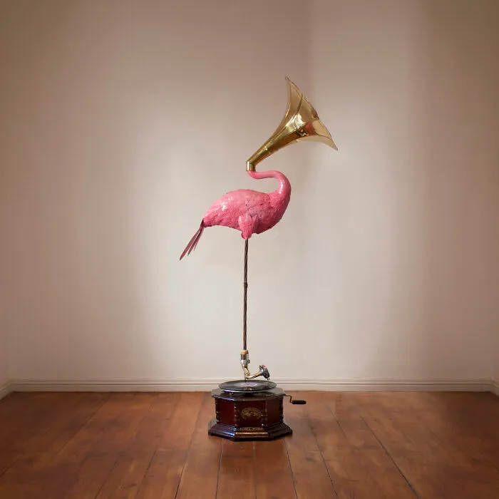 Tile works art with pink flamingo and gramophone sculpture on wooden floor