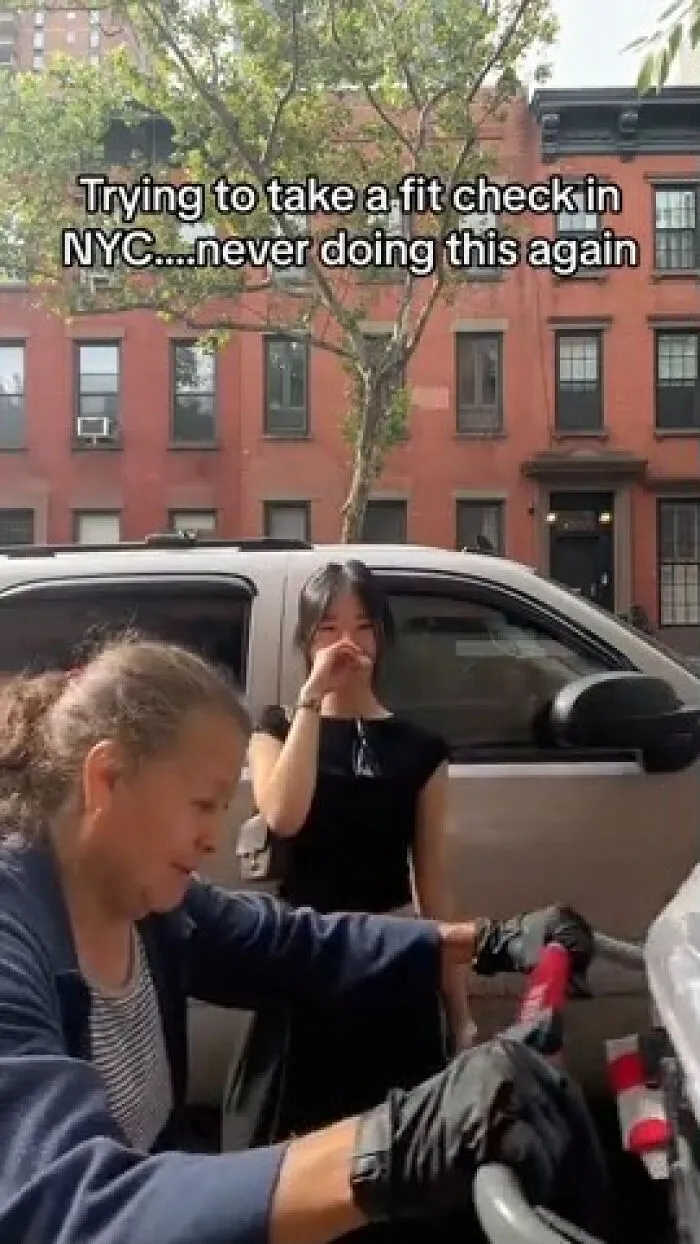 An influencer blocks a NYC street trying to take a fit check, typical of main character lives.