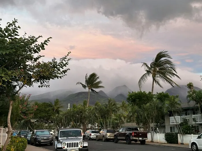 Luxury cars parked on a street with mountains in the background