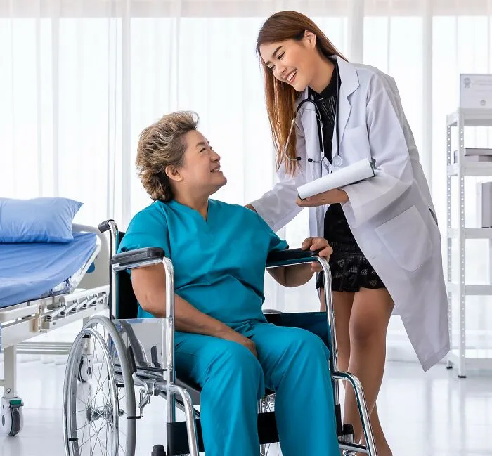 A doctor talking to an elderly woman in a wheelchair, illustrating interactions with people under medication.