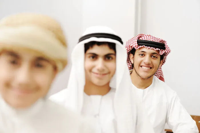 Group of smiling young men wearing traditional Middle Eastern clothing