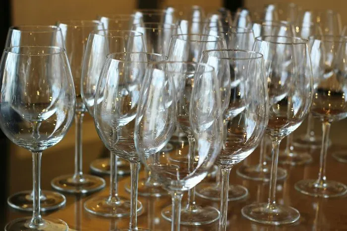 Rows of empty clean wine glasses on a wooden surface