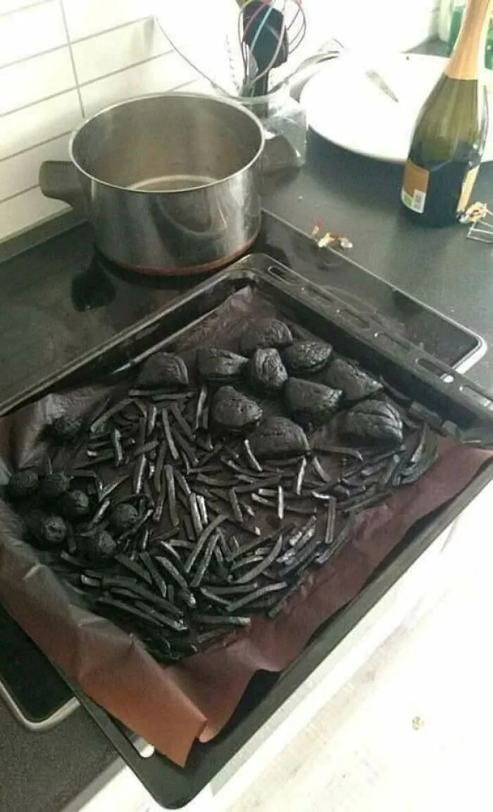 Overcooked and burnt fries and potatoes on baking tray