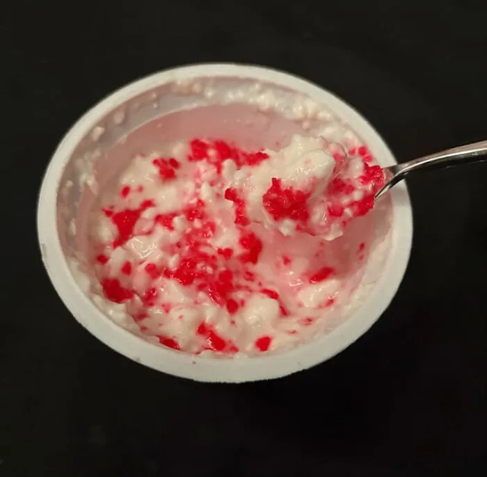 White cottage cheese mixed with red sprinkles in a cup, depicting weird food combinations.