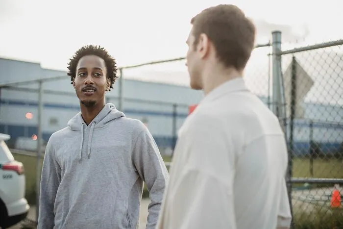 Two men discussing subtle micro-aggressions in a casual outdoor setting.