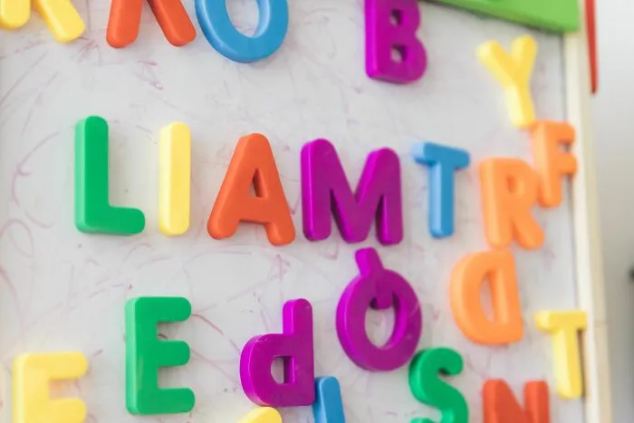Colorful magnetic letters on a whiteboard, symbolizing micro-aggressions.