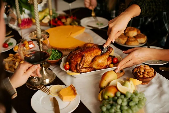 A festive table with a roasted chicken being carved, representing a social gathering where micro-aggressions might occur.