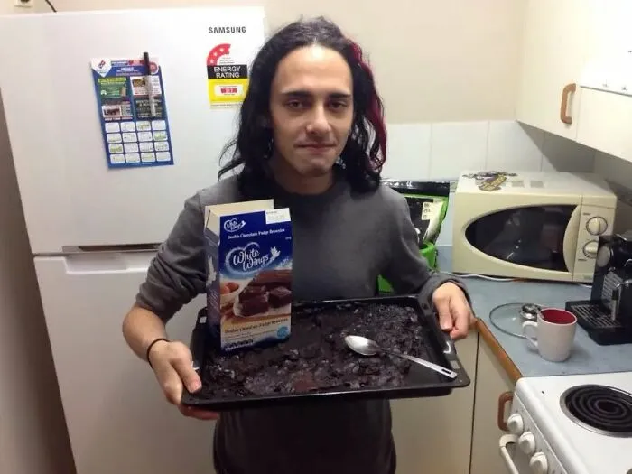 Person holding burnt brownies made from brownie mix in kitchen