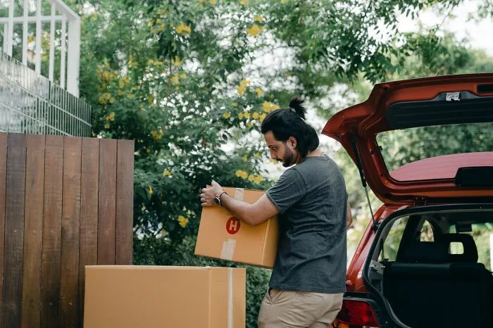 Man unloading moving boxes representing new start after family cut off