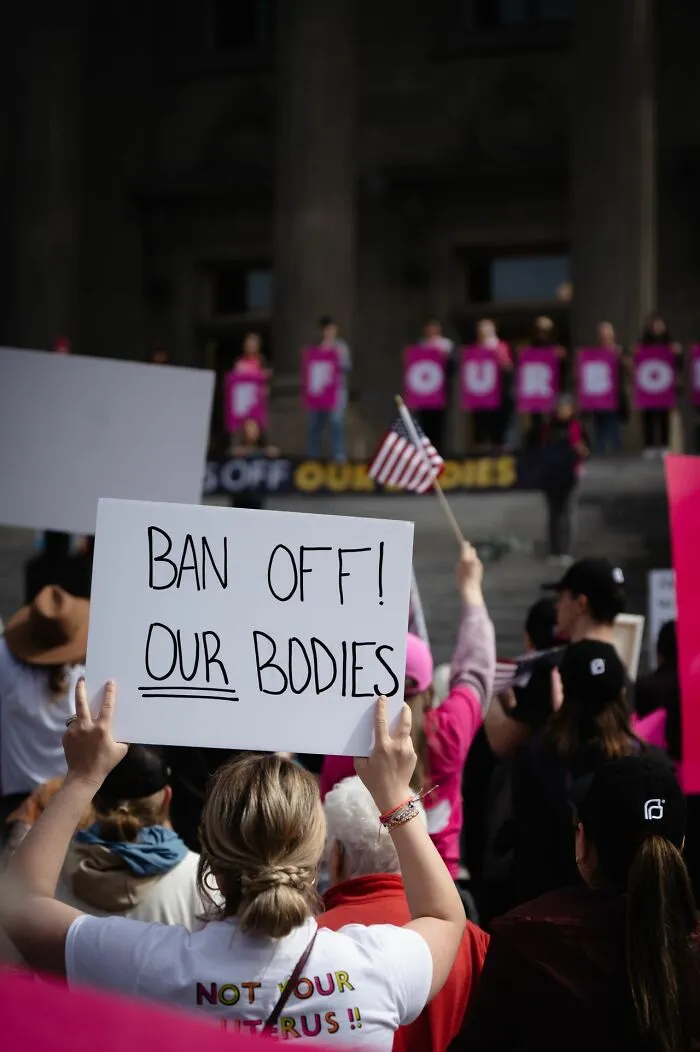 Protester holding sign at rally ban off our bodies family activism