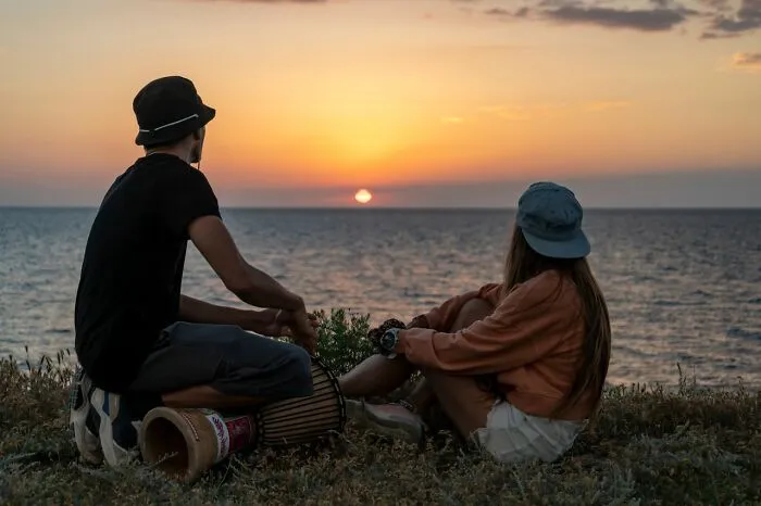 A couple watching the sunset by the ocean, depicting moments before men lose interest in a woman