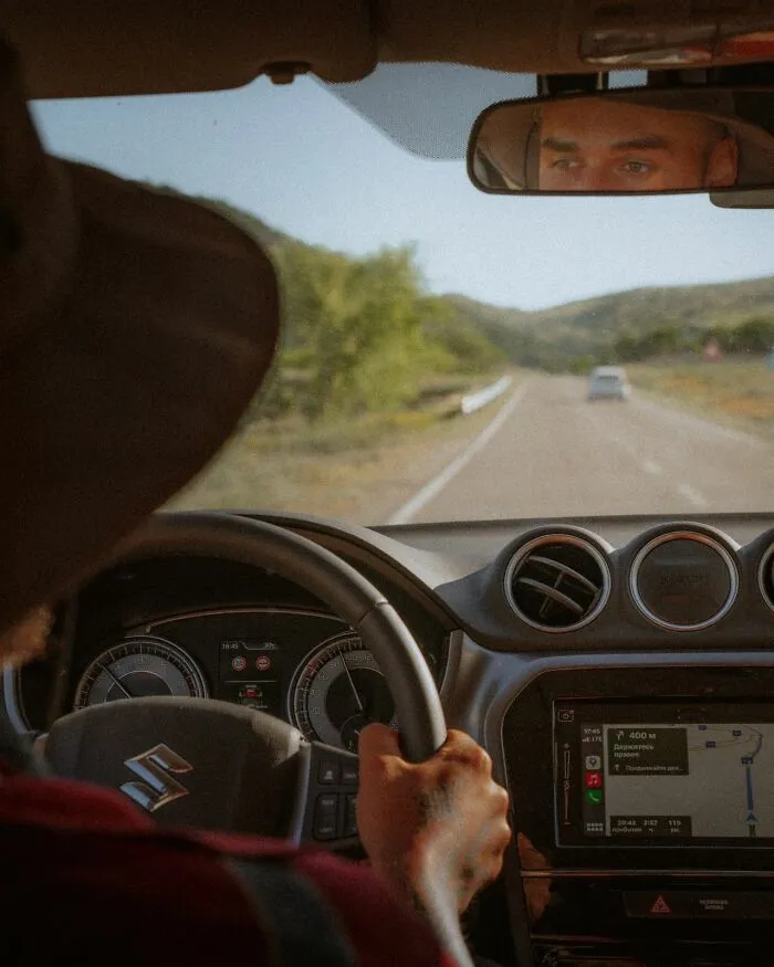 A man driving a car on an open road, pondering what makes men lose interest in a partner