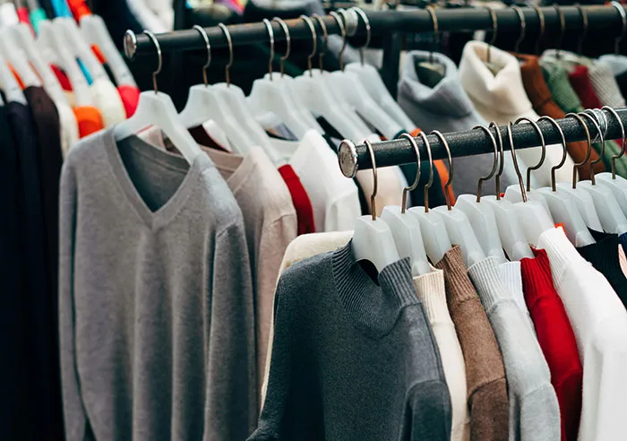 Assorted sweaters hanging on a clothing rack in a store, symbolizing encounters with entitled parents.