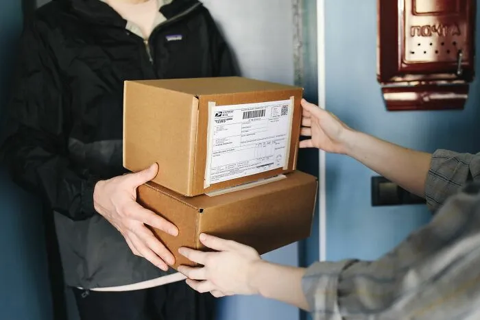 A delivery person handing over cardboard packages, representing everyday situations involving entitled parents.