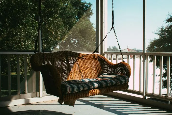 An empty wicker porch swing on a veranda, symbolizing a split and divorce.