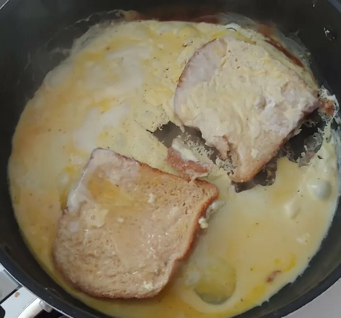 Poorly cooked eggs and bread in a pan