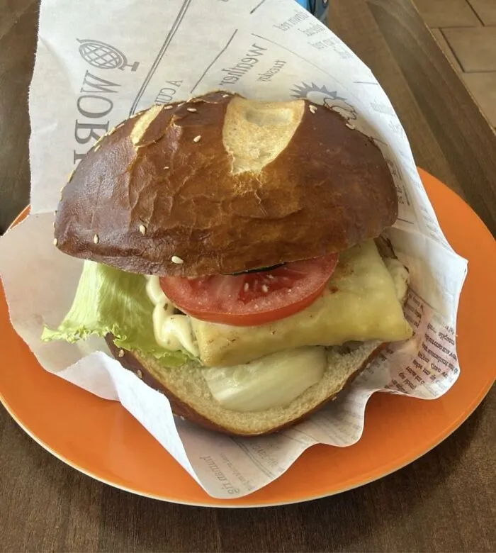 A sandwich with a thick slice of cheese, tomato, and lettuce, showing odd food combinations