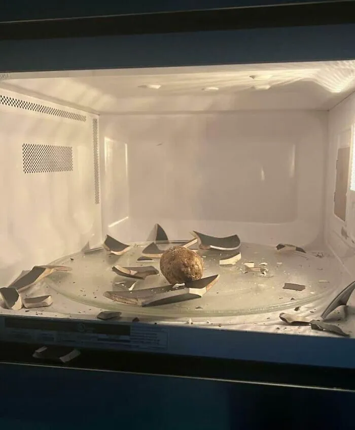 Broken glass shards in a microwave oven, illustrating unfortunate kitchen fails.