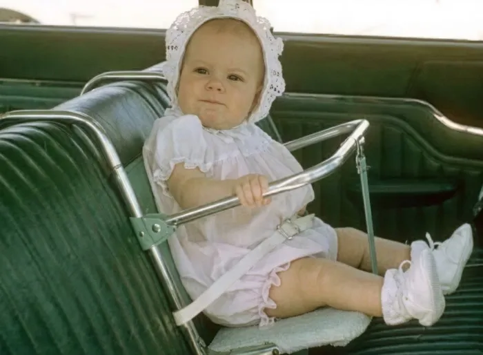 Vintage baby in retro car seat evokes childhood nostalgia for Gen X