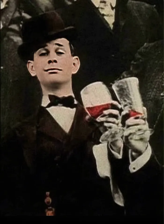 Vintage photo of man in tuxedo and hat raising a toast with wine glasses