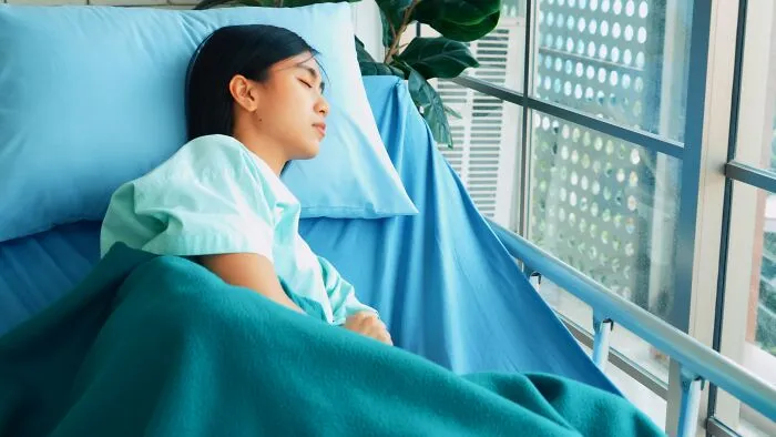 A woman sleeping in a hospital bed, possibly under medication, highlighting the bizarre things said during recovery.