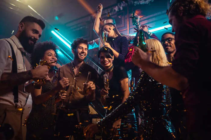 Happy friends celebrating and drinking at a party, avoiding marriage regrets