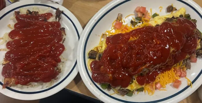 Bizarre food combinations of hash browns and an omelet completely covered in ketchup