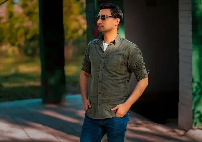 Man wearing sunglasses and casual outfit standing outdoors