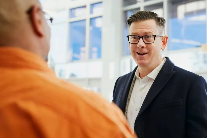 Man smiling and talking to colleague about clever insults
