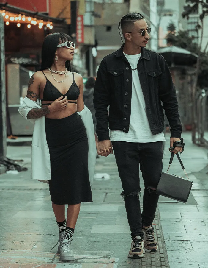 A stylish couple holding hands while walking, exemplifying modern rules for how men should treat women.