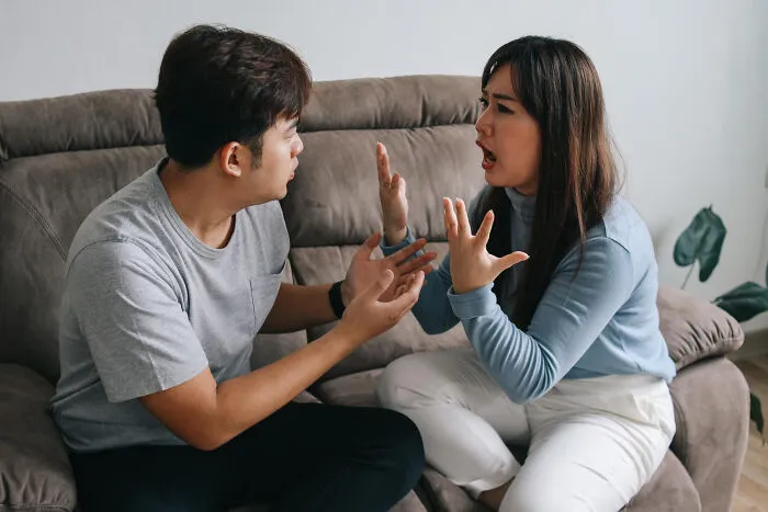 Couple arguing on couch illustrating toxic traits in love lives