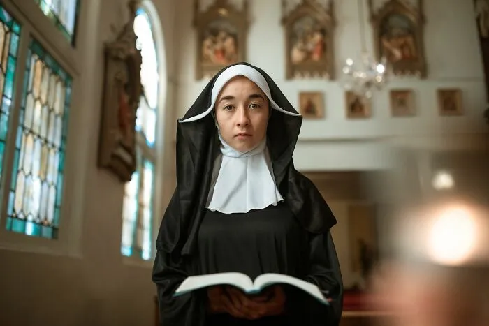 A nun holding an open book symbolizing strange stories