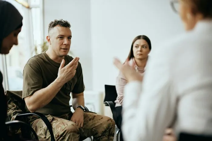 A group therapy session with a military patient sharing stories with a therapist