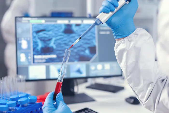 Scientist in a lab analyzing blood with a pipette, representing cheap health alternatives