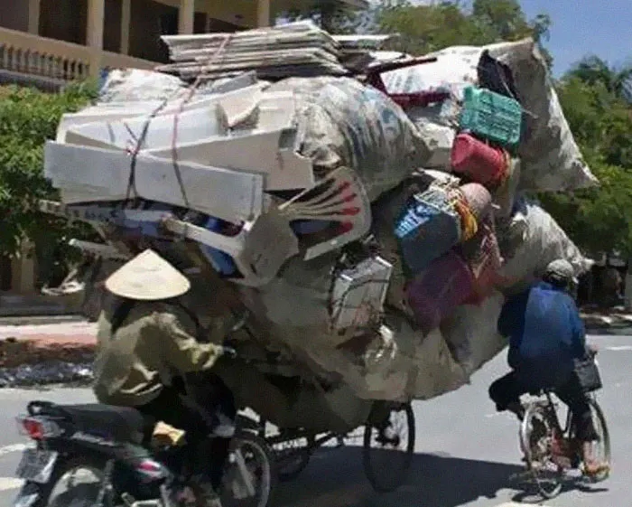 Motorbike overloaded with bags and boxes of belongings, showing an extreme moving fail