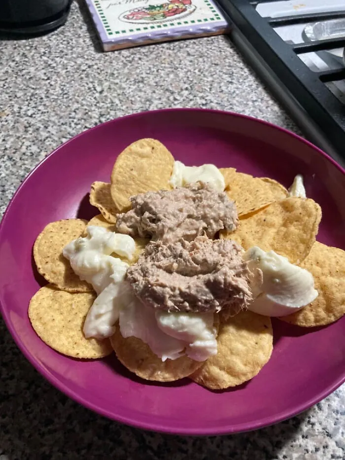 Tortilla chips topped with mayonnaise and canned tuna, an example of unusual food combinations